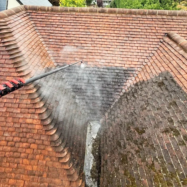 Terracotta roof being pressure washed close up.